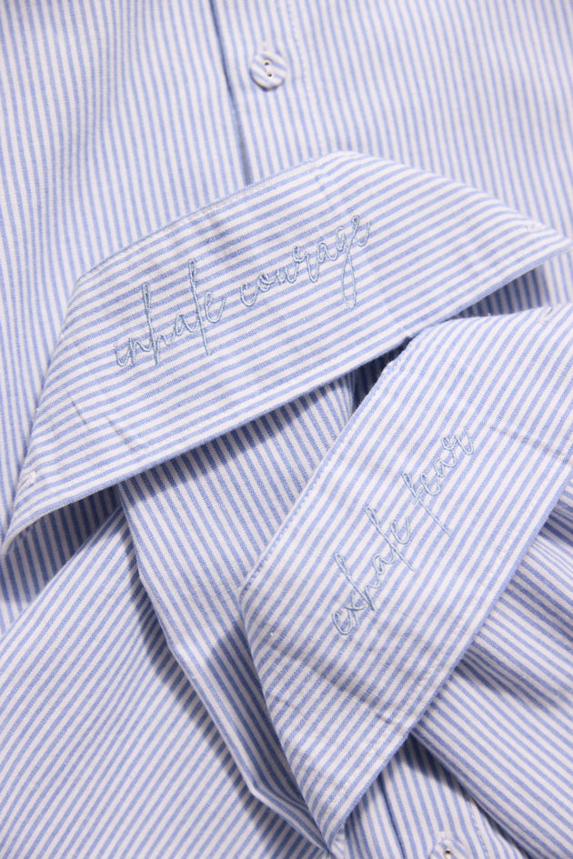 Close-up of a blue and white striped shirt with embroidery on the collar.