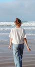 Person walking on a beach with waves in the background