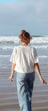 Person walking on a beach with waves in the background