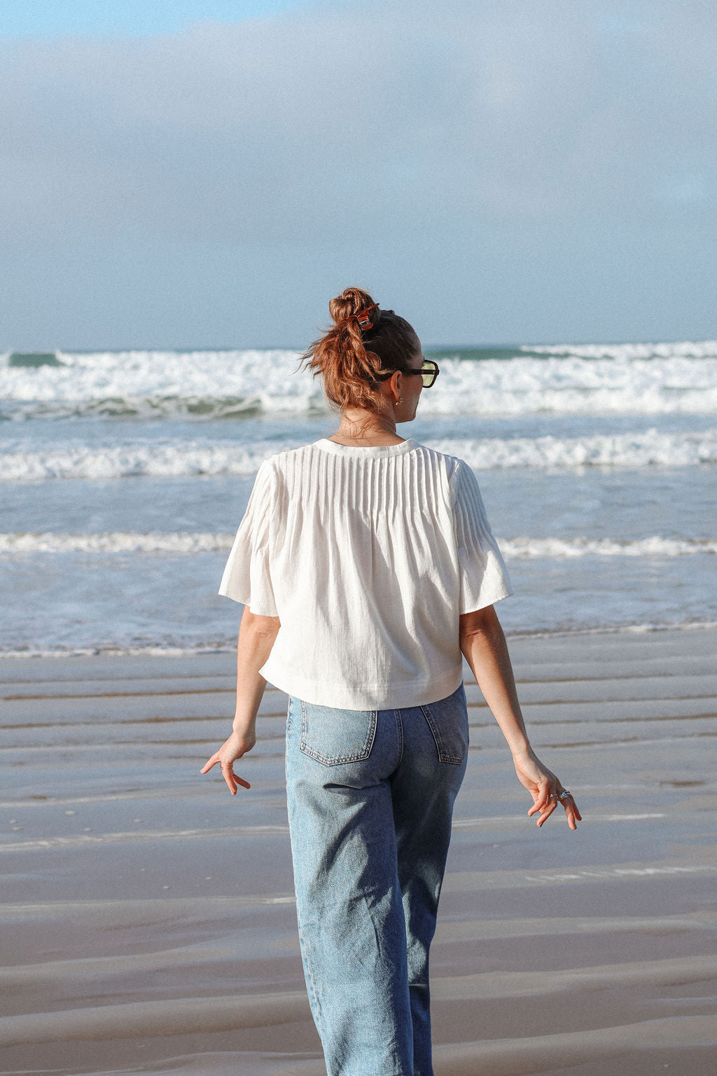 Person walking on a beach with waves in the background