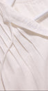 Close-up of a white garment with 'Ibreath' embroidery on a light background