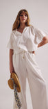 Woman wearing a white outfit with a plain background