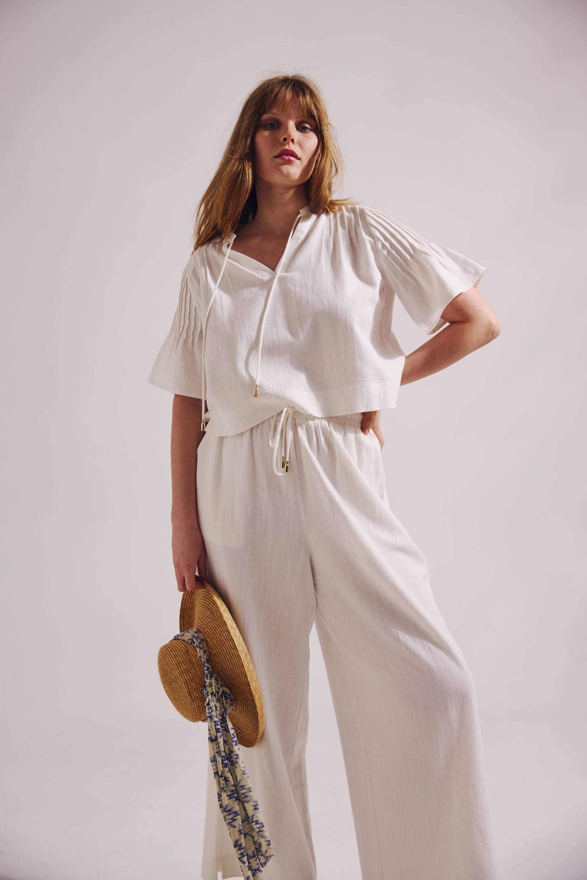 Woman wearing a white outfit with a plain background