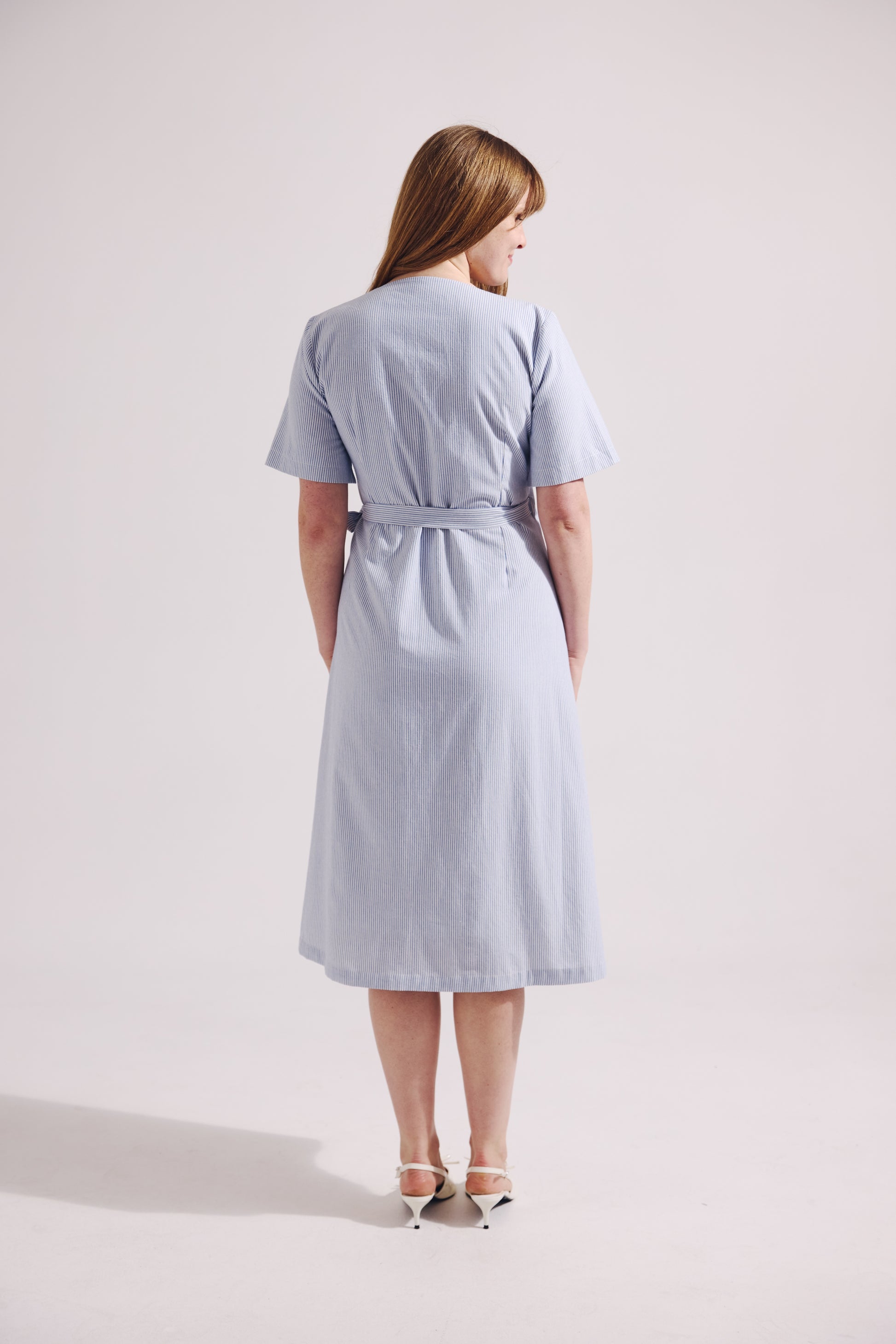 Woman wearing a light blue dress on a white background