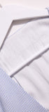 Close-up of a white shirt with blue striped collar and cuffs.