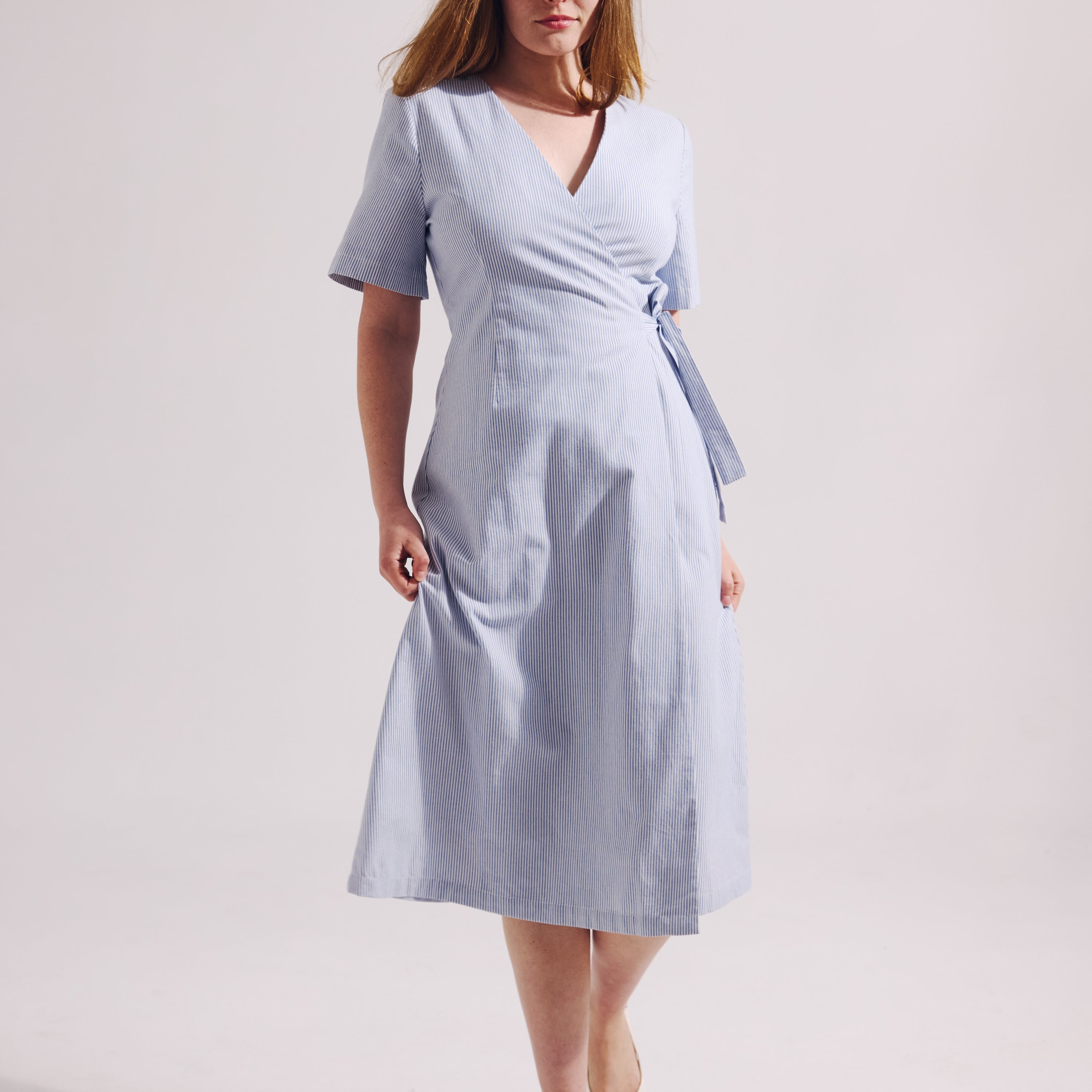 Woman wearing a light blue dress on a white background