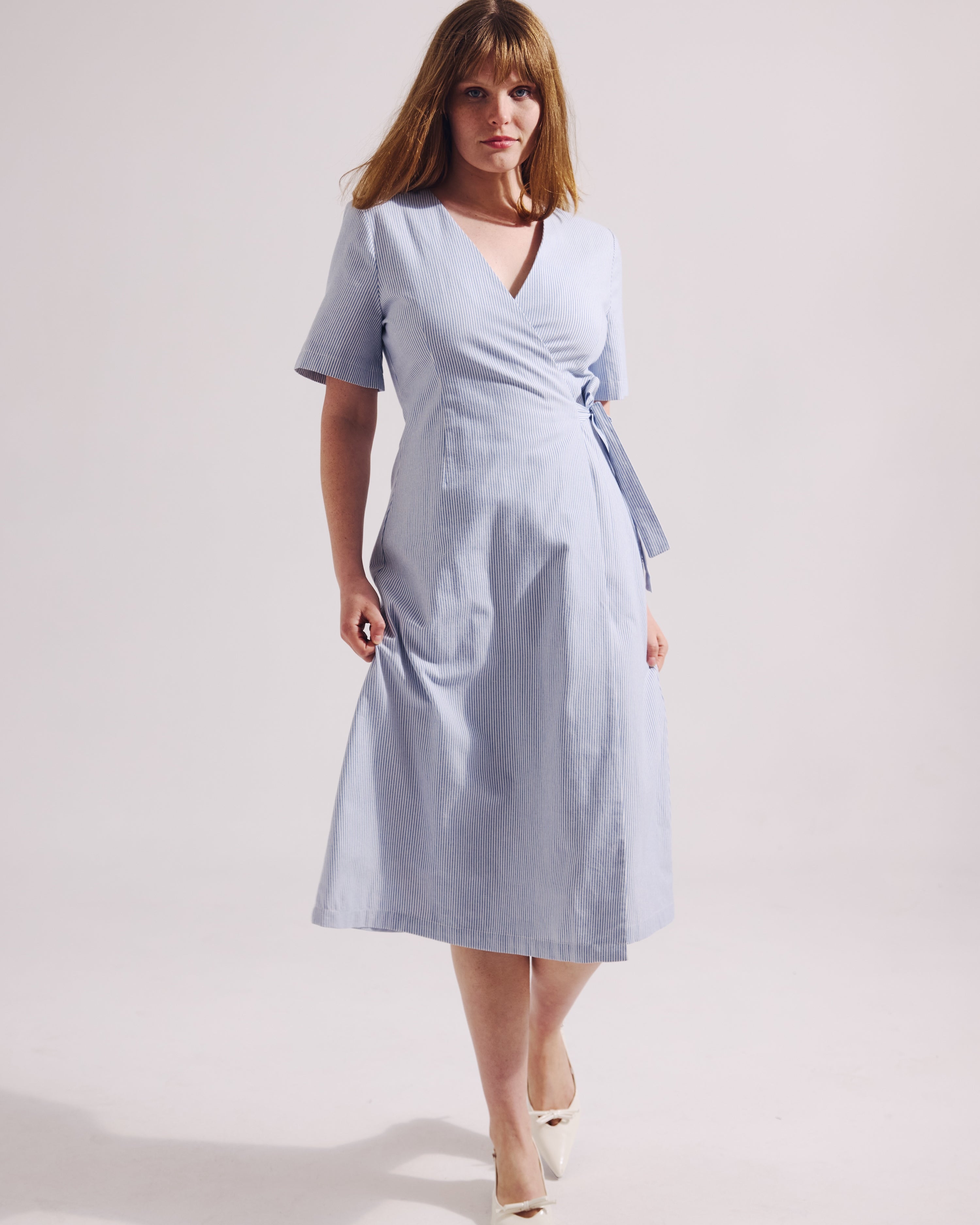 Woman wearing a light blue dress on a white background