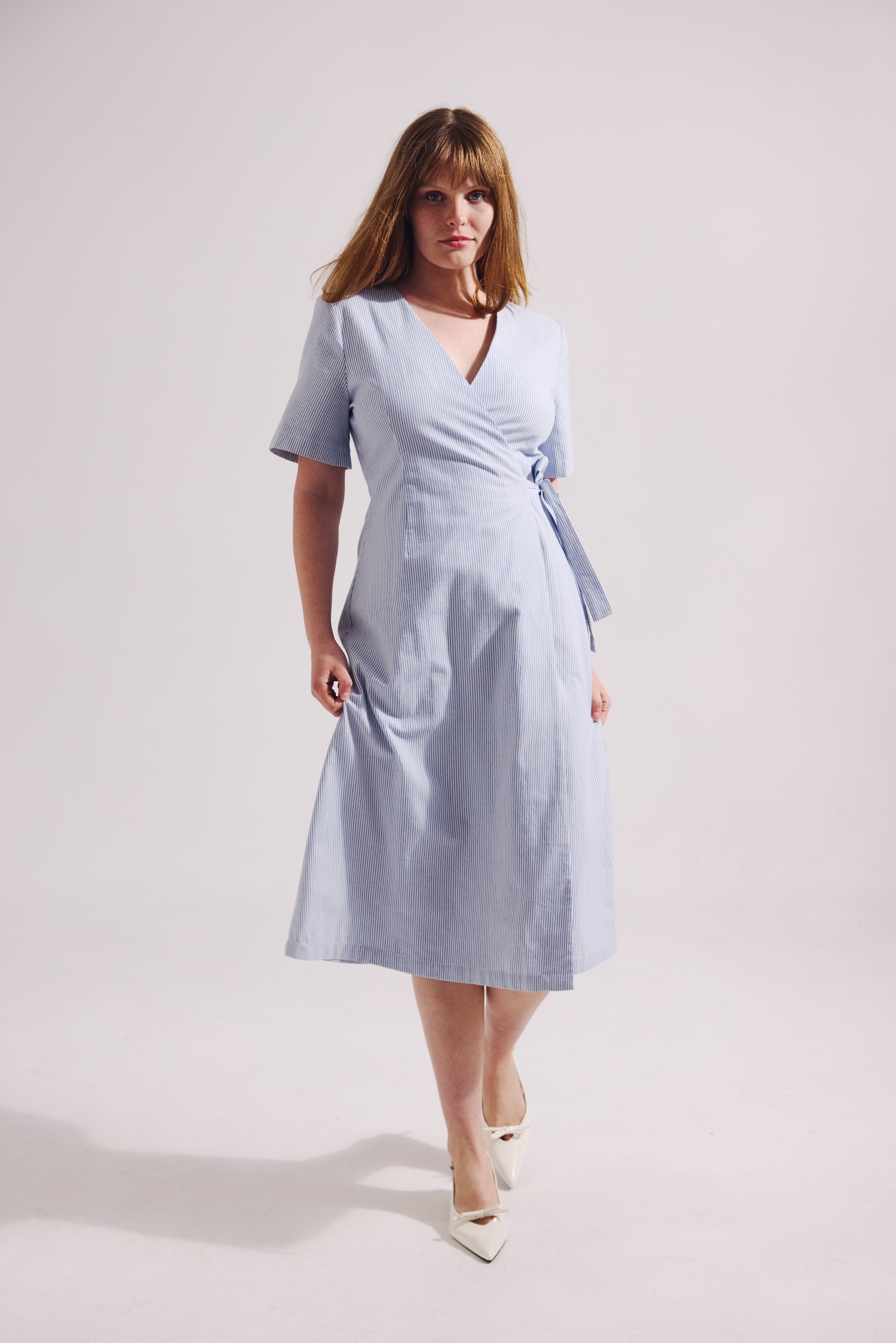 Woman wearing a light blue dress on a white background