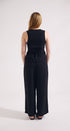 Person wearing a black sleeveless jumpsuit on a white background