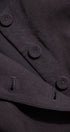 Close-up of a dark coat with buttons and visible branding.