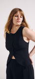 Woman wearing a black sleeveless top and skirt against a white background