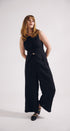 Woman wearing a black sleeveless top and wide-leg pants on a white background