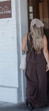 Person in a brown dress standing outside a building with a sign that reads 'Old Grain Store'.