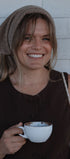 Woman holding a white mug with a brown background