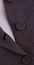 Close-up of a brown textured fabric with buttons and stitching details.