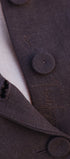 Close-up of a brown textured fabric with buttons and stitching details.
