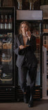 Person in a dark suit standing in front of a refrigerator in a store.
