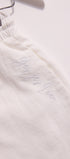 White garment with 'Justine' embroidered on it, hanging against a white background.