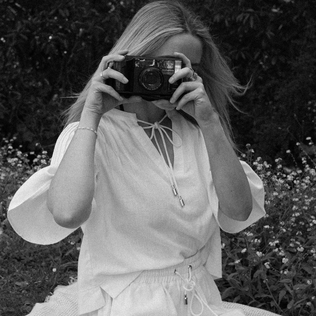 Person taking a photo with an old camera in a natural setting