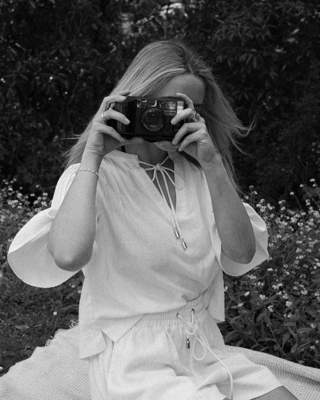 Person taking a photo with an old camera in a natural setting
