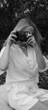 Person taking a photo with an old camera in a natural setting