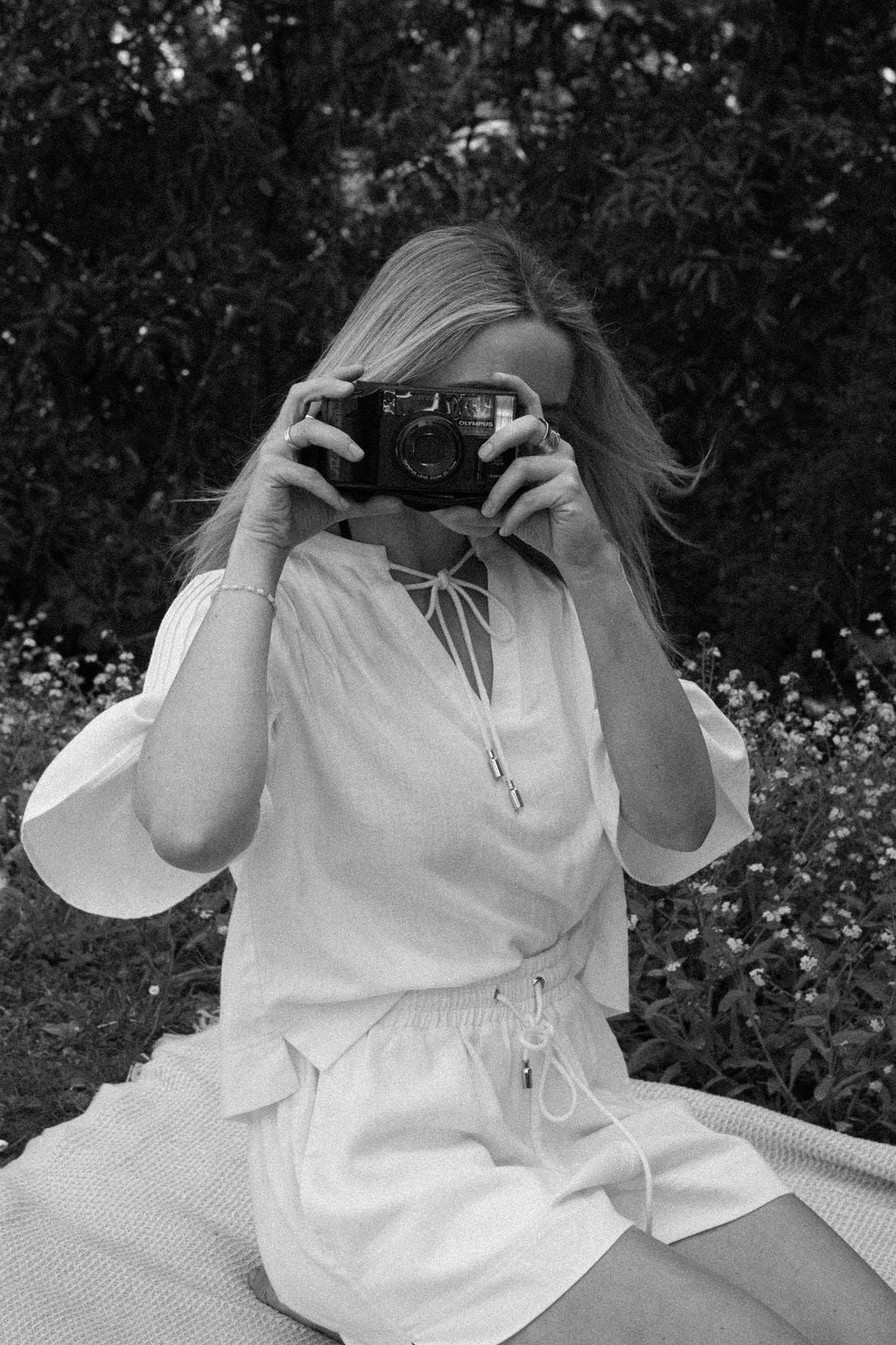Person taking a photo with an old camera in a natural setting