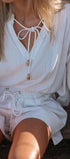 Person wearing a white outfit with a close-up of the neckline.