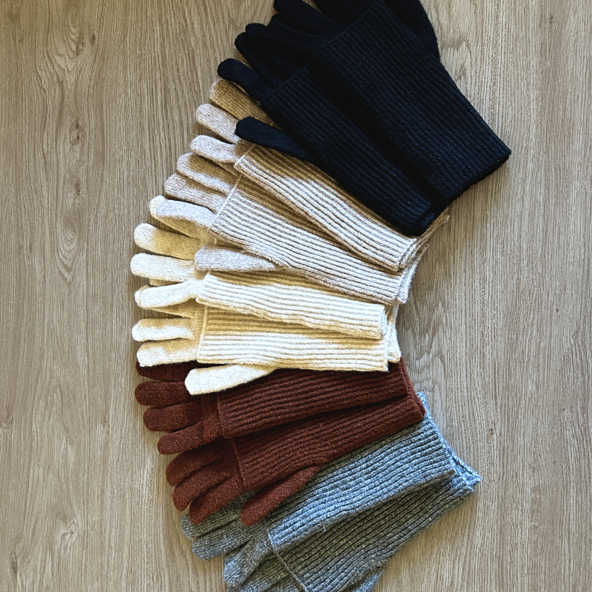 Set of colorful gloves arranged on a wooden surface
