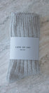 Packaged beige socks with 'LOVE OF IVY' label on a marble surface