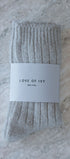 Packaged beige socks with 'LOVE OF IVY' label on a marble surface