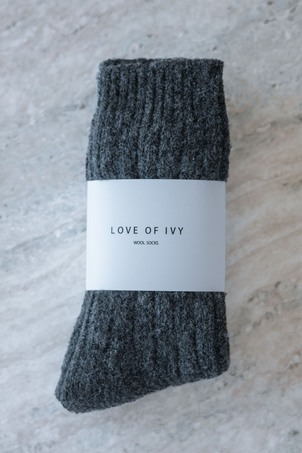 Gray socks with a white label on a textured surface