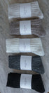 Five pairs of socks in black, gray, white, brown, and beige on a marble surface with 'Love of Ivy' labels.
