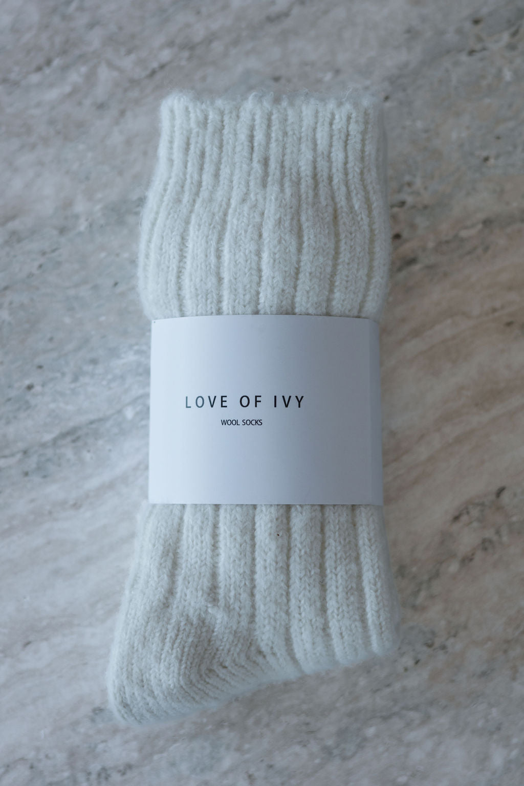 cream sock with 'Love of Ivy' label on a textured surface