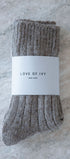light brown socks with a 'Love of Ivy' label on a textured surface