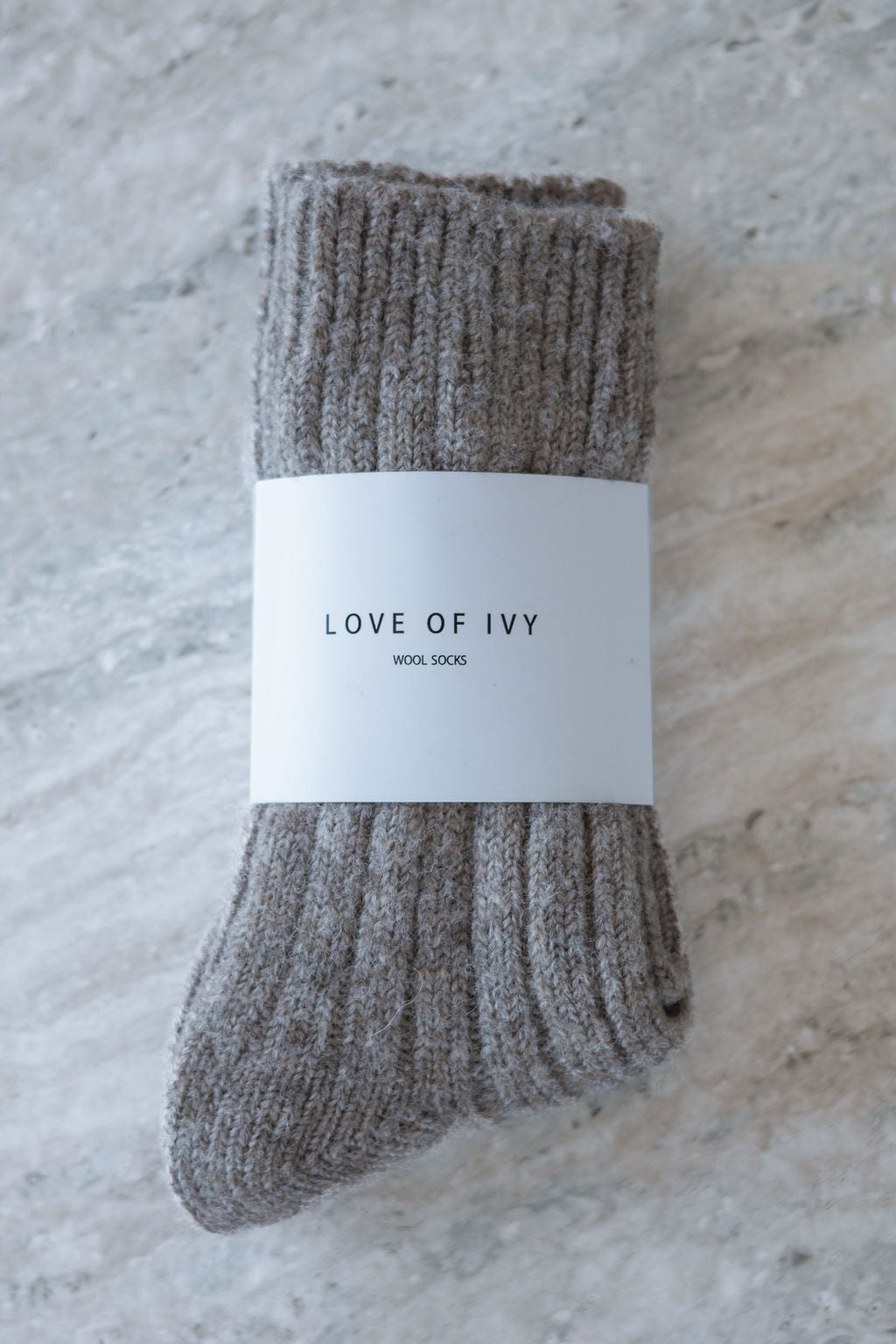 light brown socks with a 'Love of Ivy' label on a textured surface