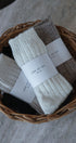 Three pairs of socks in a wicker basket with 'Love of Ivy' labels.