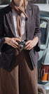Person holding a camera with a vintage car in the background