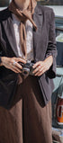 Person holding a camera with a vintage car in the background